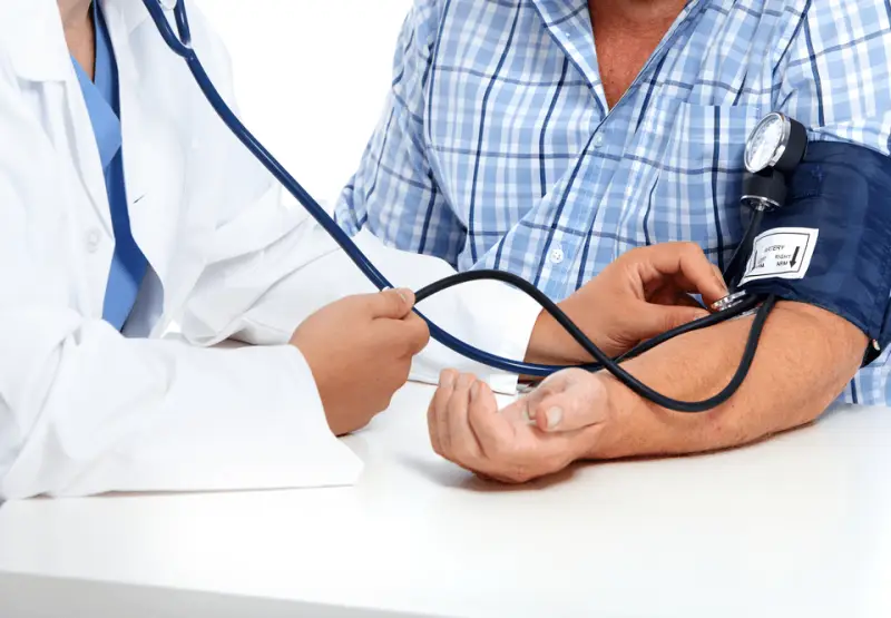 Médico verificando a pressão arterial de um paciente